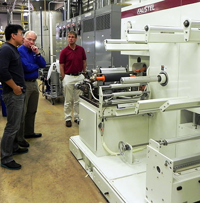 Roland Gong, Assistant Professor for Paper Science & Engineering; Rick Ruenzel, Sales Engineer for Faustel; and Paul Fowler, Executive Director of the Wisconsin Institute for Sustainable Technology inspect the newly installed LabMaster Pilot Coater.